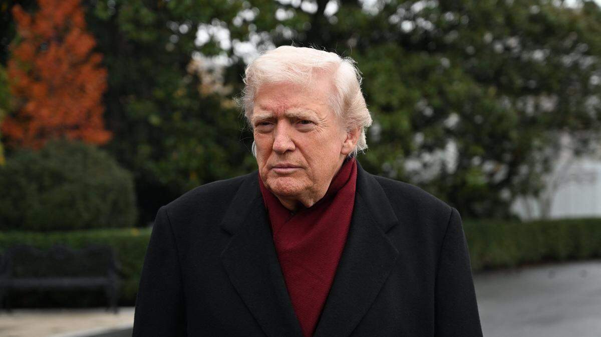 US President Donald Trump listens while taking questions from the press before boarding Marine One on the South Lawn of the White House in Washington, DC, on November 22, 2025 as he heads to visit The Courses at Joint Base Andrews, Maryland. (Photo by Alex WROBLEWSKI / AFP via Getty Images)