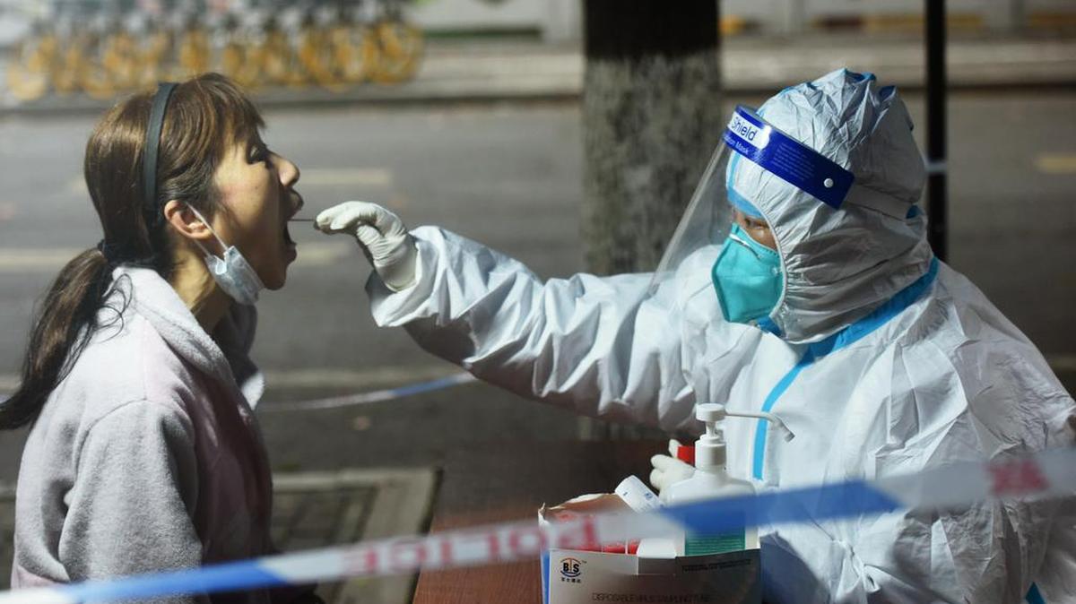 Un trabajador médico toma una muestra de hisopo de un residente para la prueba de COVID-19 en Hangzhou, en la provincia de Zhejiang,
