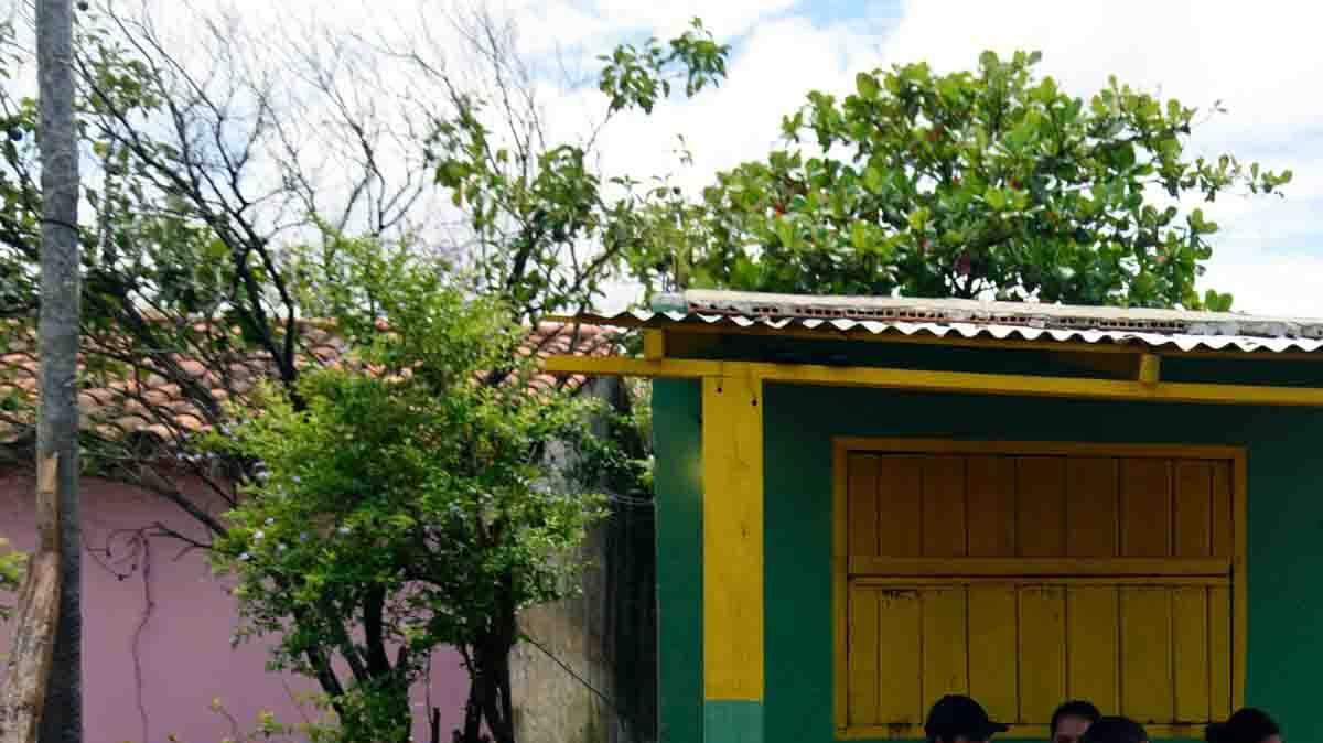 Un grupo de personas se sienta en la puerta de una vivienda en Falcón, a 42 kilómetros de Asunción, en la frontera entre Paraguay y Argentina, el 26 de diciembre. 