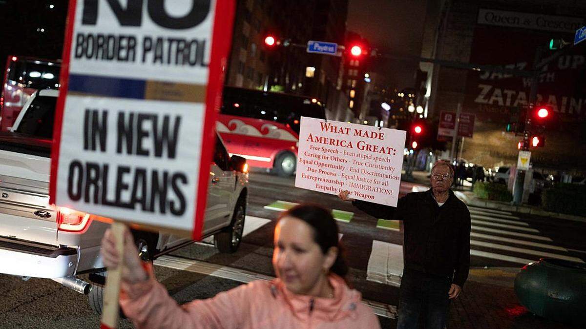 People hold signs during a protest against the US Border Patrol and the Immigration and Customs Enforcement (ICE) outside of Hale Boggs Federal Building in New Orleans, Louisiana, on December 6, 2025. The US Department of Homeland Security announced on December 3 it has launched a federal immigration enforcement operation, named "Operation Catahoula Crunch," in the New Orleans, Louisiana, area. (Photo by Adam GRAY / AFP via Getty Images)
