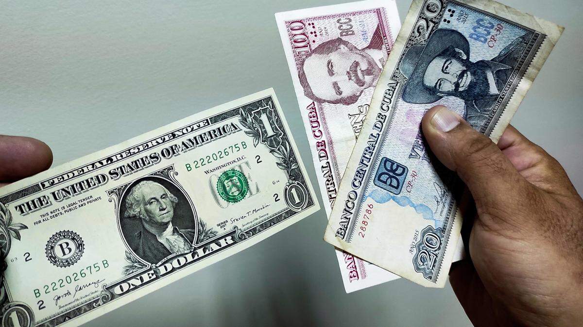 Un hombre muestra un dólar y pesos cubanos en La Habana, el 4 de agosto de 2022.