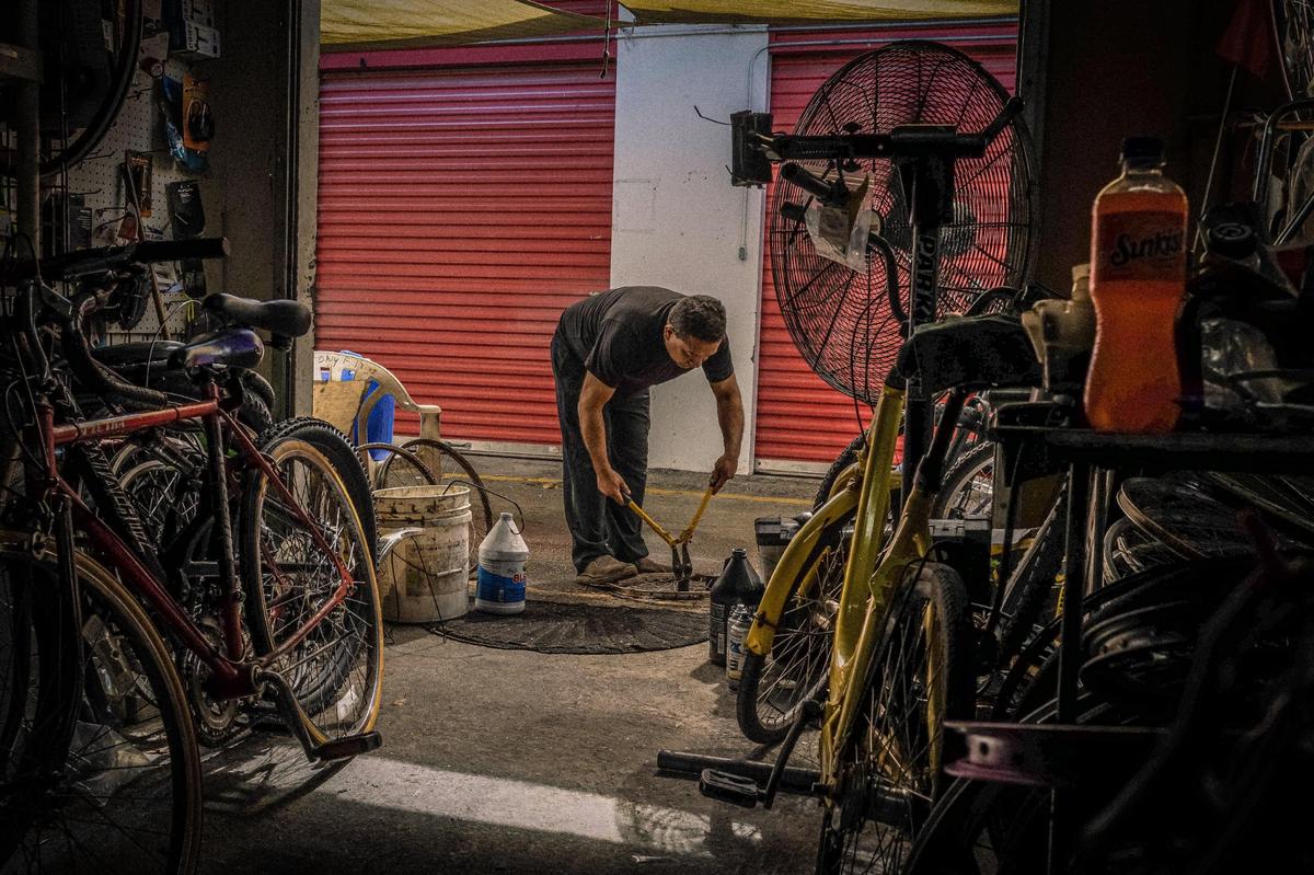 Carlos José, repara y restaura bicicletas. Nacido en Guatemala. La fotografía es parte de un proyecto “Immigrant Life at Homestead’s Redland Market” del fotógrafo venezolano Carlos “Cali” Muñoz, quien recientemente ganó la beca de Fotografía 2023 del Centro de Fotografía del Museo HistoryMiami para fotógrafos documentales locales emergentes