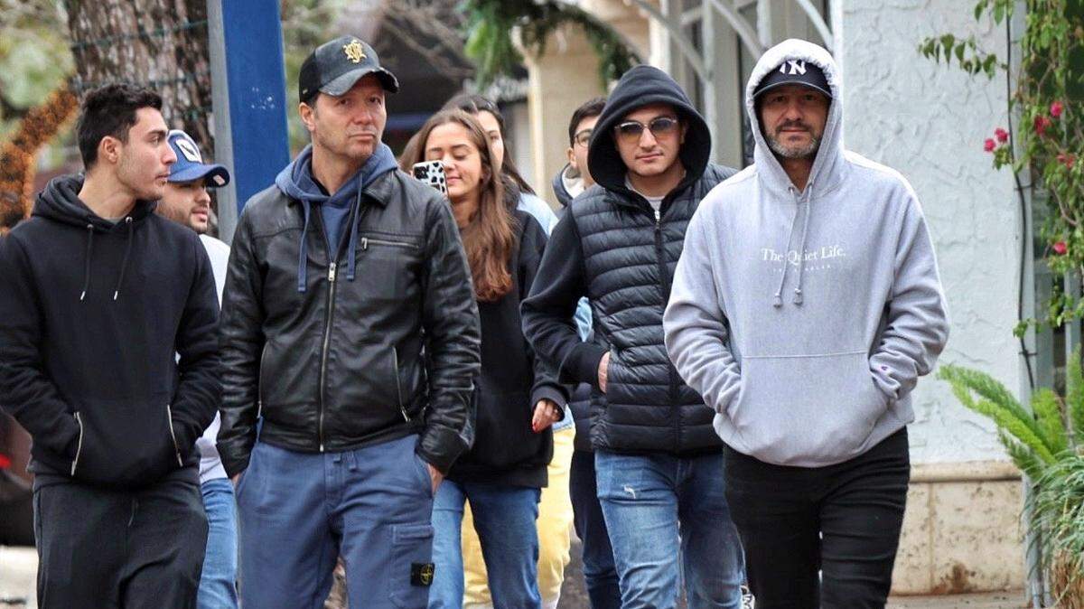 People wearing jackets and hoodies walk in Miami’s Coconut Grove neighborhood on Sunday, Dec. 25, 2022. A cold front is moving across South Florida, and temperatures will drop starting Monday night, according to the National Weather Service in Miami.