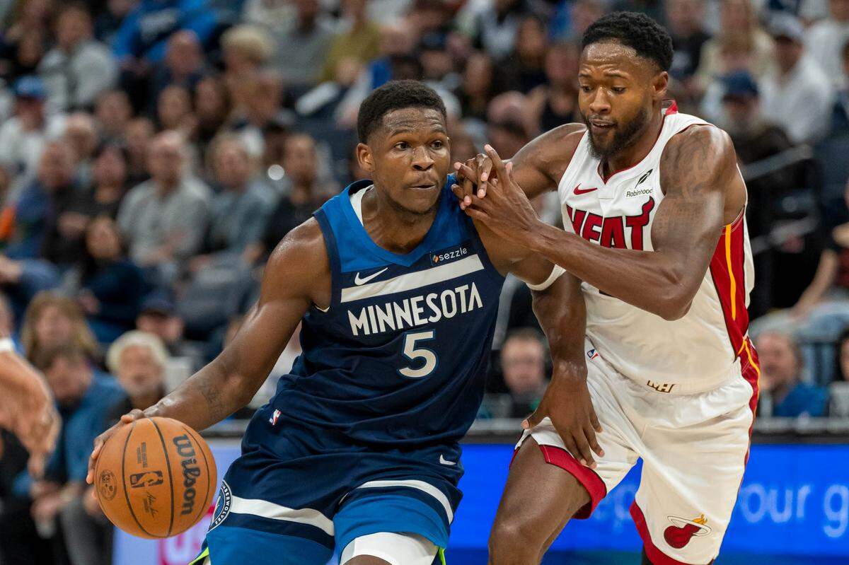El jugador de los Timberwolves Anthony Edwards (izq.) entra al aro ante la marca de Haywood Highsmith, del Heat de Miami, en el partido celebrado el 10 de noviembre de 2024 en Minneapolis, Minnesota.