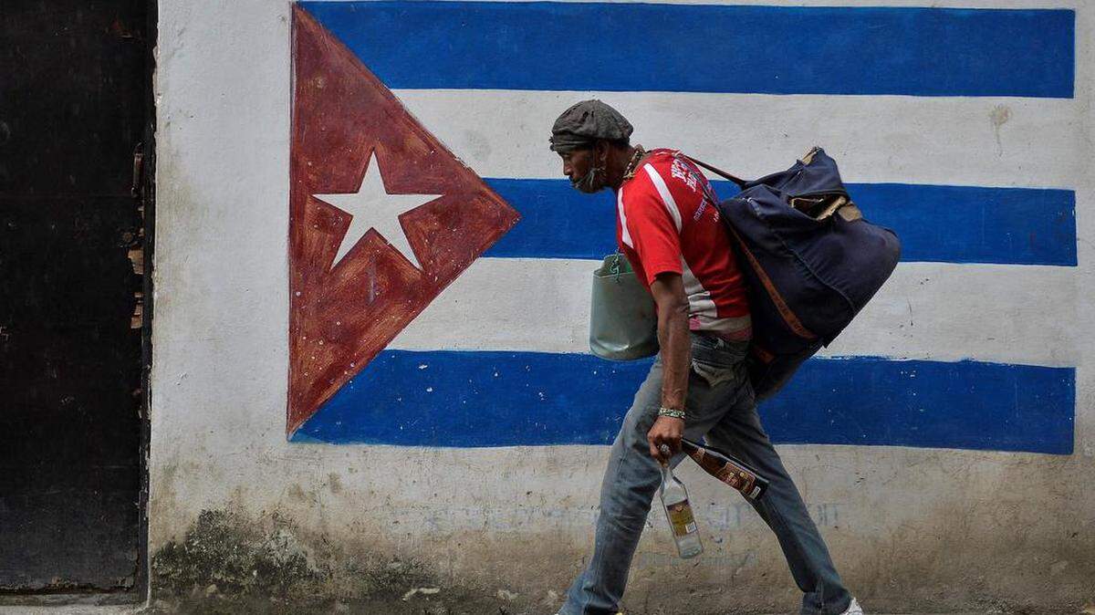 A man walks past a graffiti of the Cuban flag in Havana, on January 12, 2021.