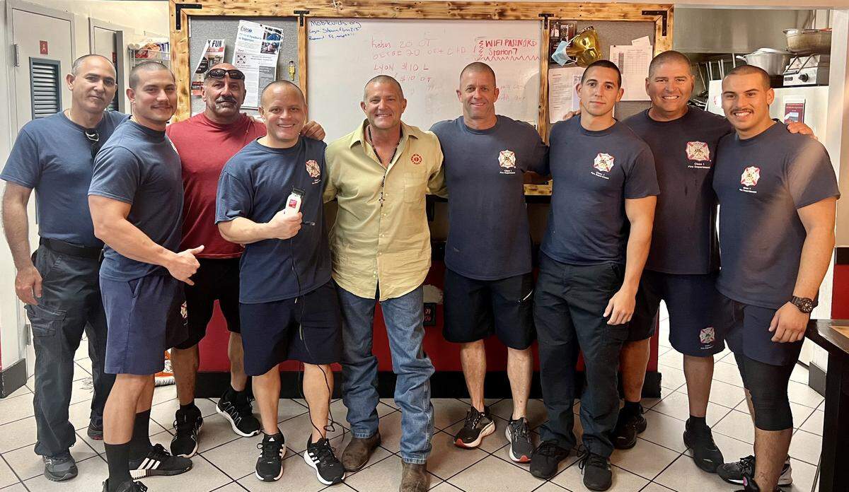 De izquierda a derecha el ingeniero Angel Álvarez, el bombero Yadiel Domínguez, el ingeniero JJ Arriola, el jefe de distrito Steve Lyon, en el centro el bombero Eric Johnson, el bombero Roy Huff, el ingeniero Joey Fresneda, el teniente Julian Troncoso y el bombero Dimitri Rodríguez. Todos se afeitaron el cabello en respaldo a Johnson quien ha sido diagnosticado con cáncer de colon