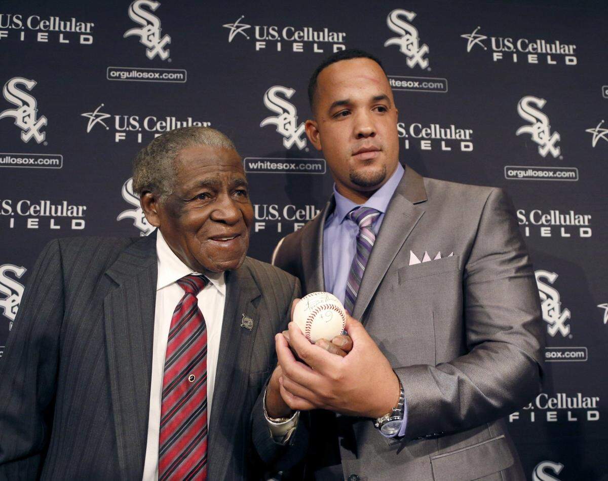 José Abreu (der.) posa con Orestes Miñoso en su presentación como peloteros de los Medias Blancas, el el 29 de octubre de 2013 en Chicago.