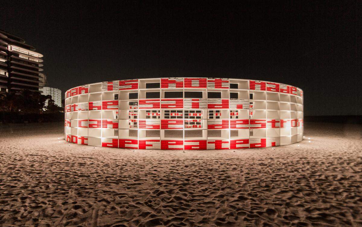 Instalación monumental de Alexandre Arrechea en forma de rotonda de 62 pies de diámetro (18 metros aproximadamente), con apariencia de una biblioteca cuyas estanterías, en lugar de libros, están compactadas por toallas.