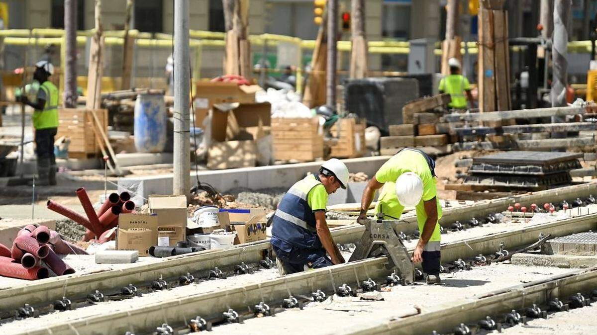 Obreros trabajan en la construcción de una nueva línea de tranvía, el 18 de julio de 2023 en Barcelona, España. 