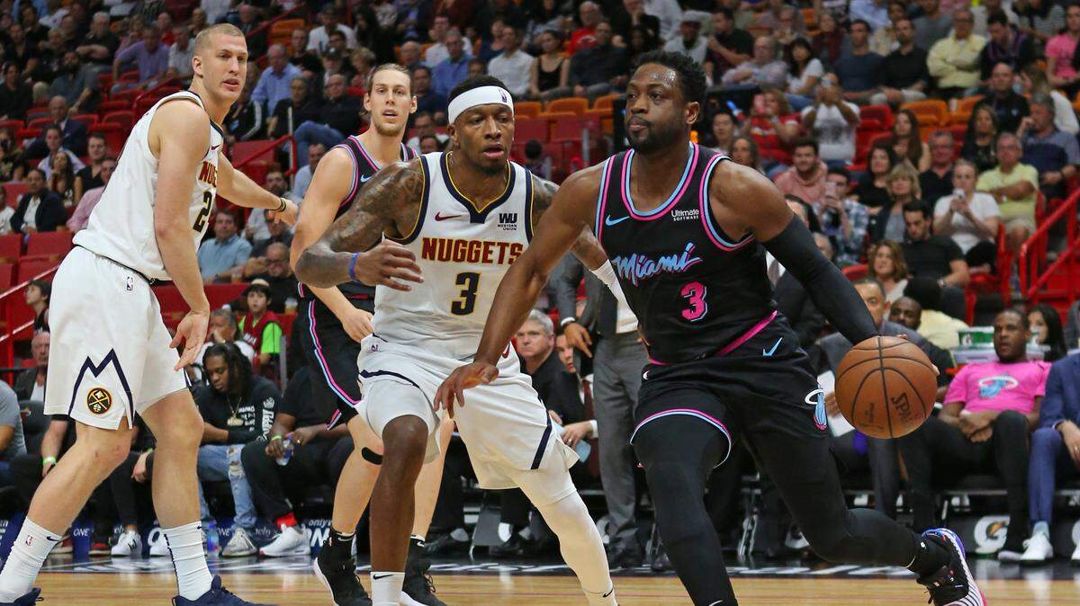 El jugador del Heat Dwyane Wade conduce la pelota ante la marca de Torrey Craig, de los Nuggets, en el primer cuarto del partido celebrado el 8 de enero de 2019 en Miami.