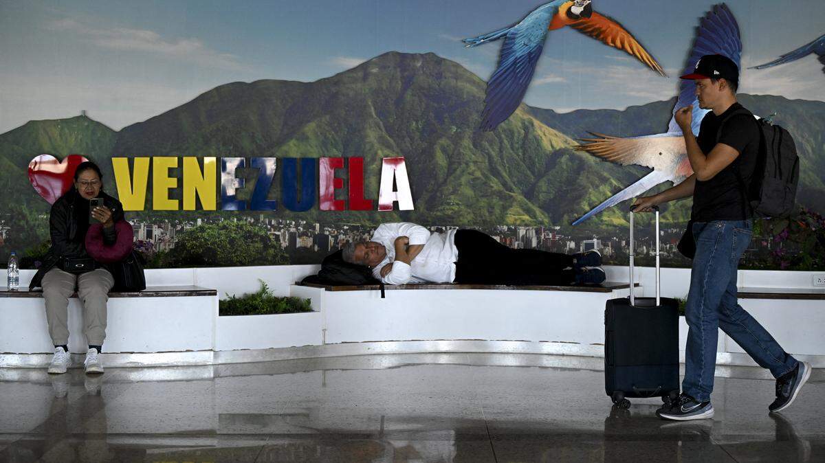 Personas descansan cerca de una puerta de embarque en el Aeropuerto Internacional Simón Bolívar en Maiquetía, estado La Guaira, Venezuela, el 30 de noviembre de 2025.