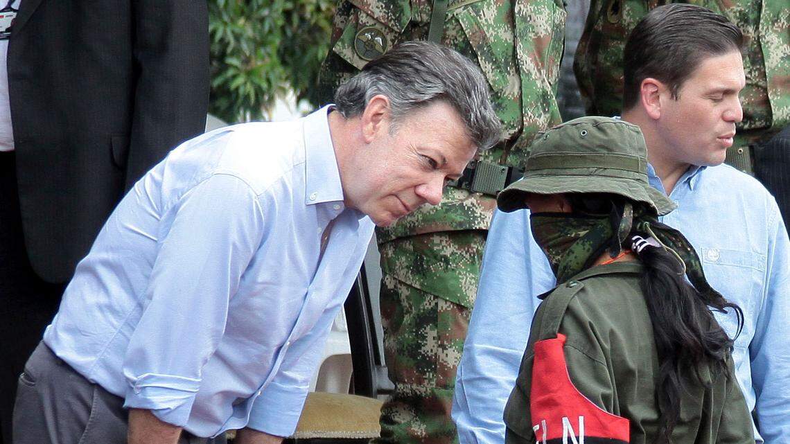 El presidente de Colombia, Juan Manuel Santos, habla con una jovencita rebelde del Ejército de Liberación Nacional (ELN), quien se entregó en una base militar en Cali el 16 de julio del 2013.