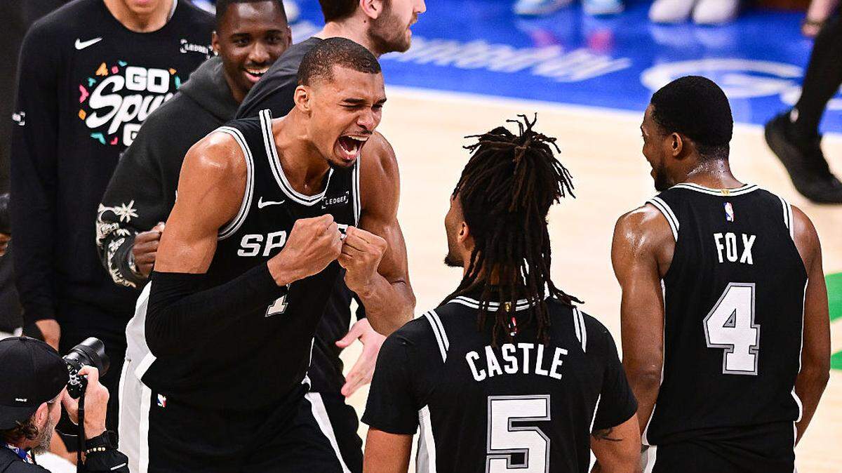 El astro de los Spurs de San Antonio Victor Wembanyama (centro) celebra con sus compañeros de equipo tras vencer al Thunder y proclamarse campeones de la Conferencia Oeste de la NBA, en el séptimo partido del playoff efectuado el 30 de mayo de 2026 en Oklahoma City, Oklahoma. 