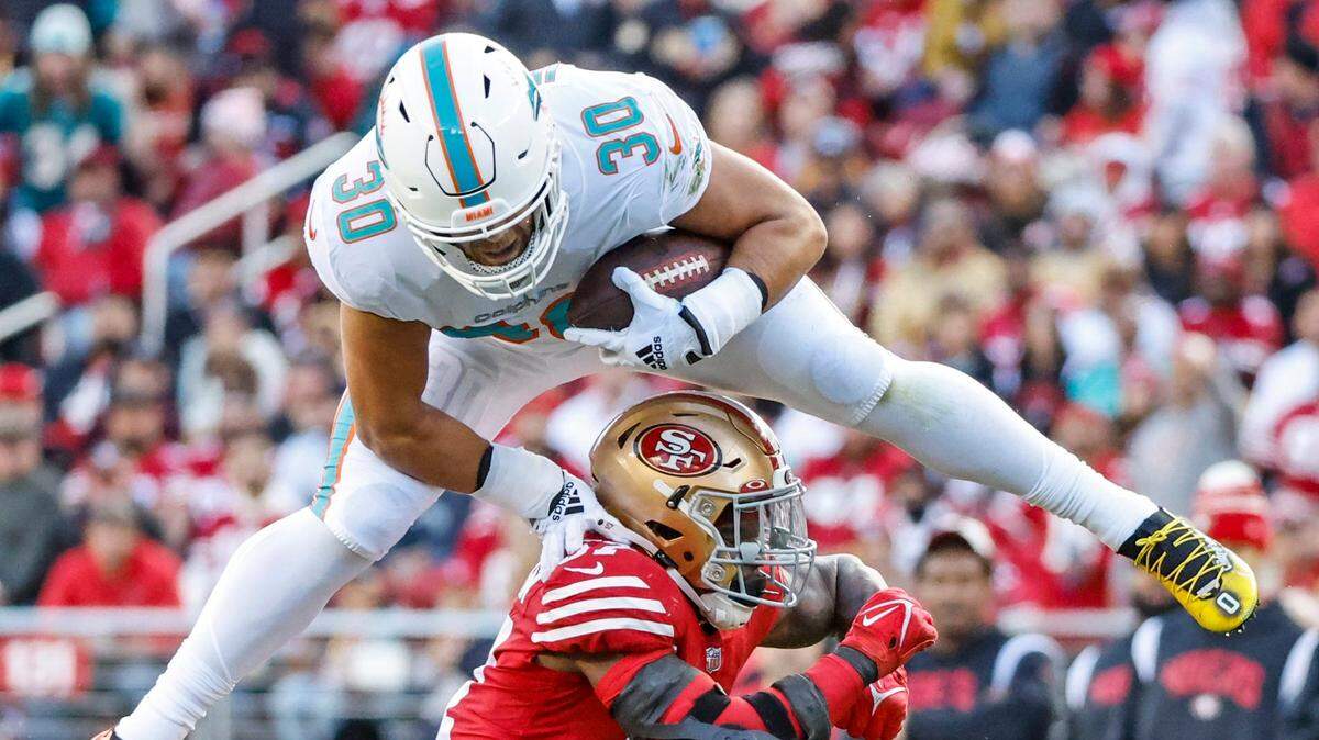 El fullback de los Dolphins Alec Ingold salta sobre el linebacker de los 49ers de San Francisco Dre Greenlaw, en el partido celebrado el 4 de diciembre de 2022 en Santa Clara, California.