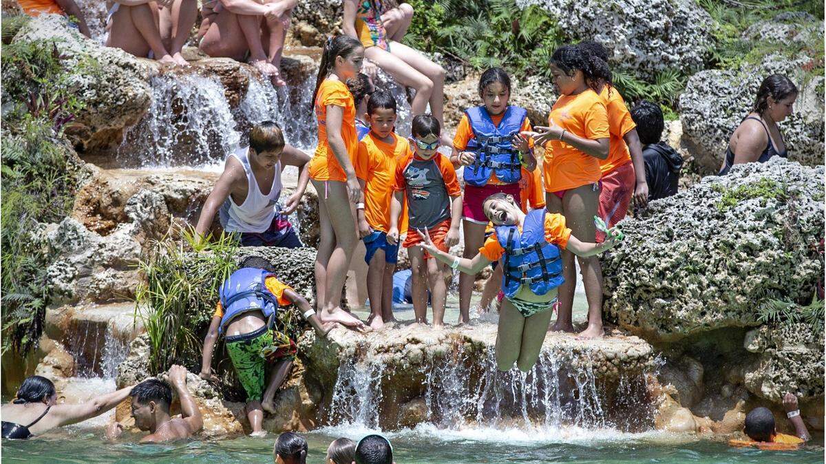 In this file photo from June 21, 2019, a group of summer campers jump into the cool 77 degree waters of Venetian Pool in Coral Gables. As South Florida continues to bask in similar warmth and dry days forecast March 24, 2023, through the weekend, finding cool water may be a treat.