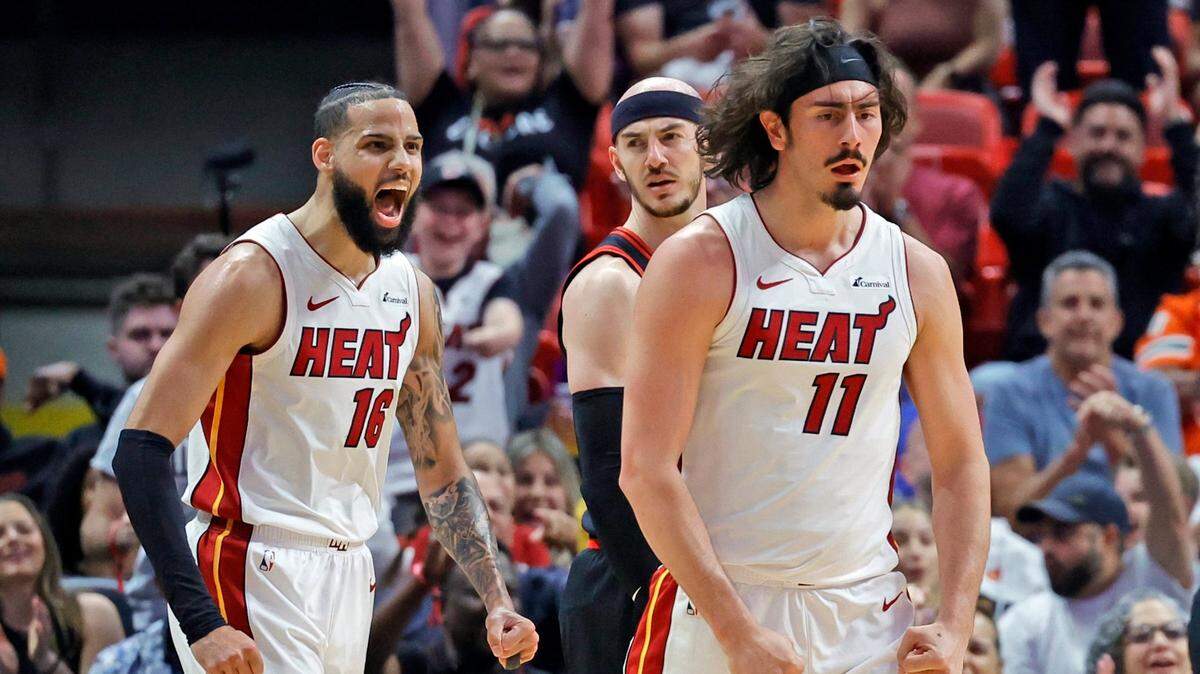 El novato del Heat Jaime Jáquez Jr. (der.) y el delantero Caleb Martin (16) reaccionan después de que Jáquez Jr. anotara una canasta contra los Bulls de Chicago, en el primer cuarto del partido de play-in celebrado el 18 de abril de 2024 en el Kaseya Center en Miami, Florida.