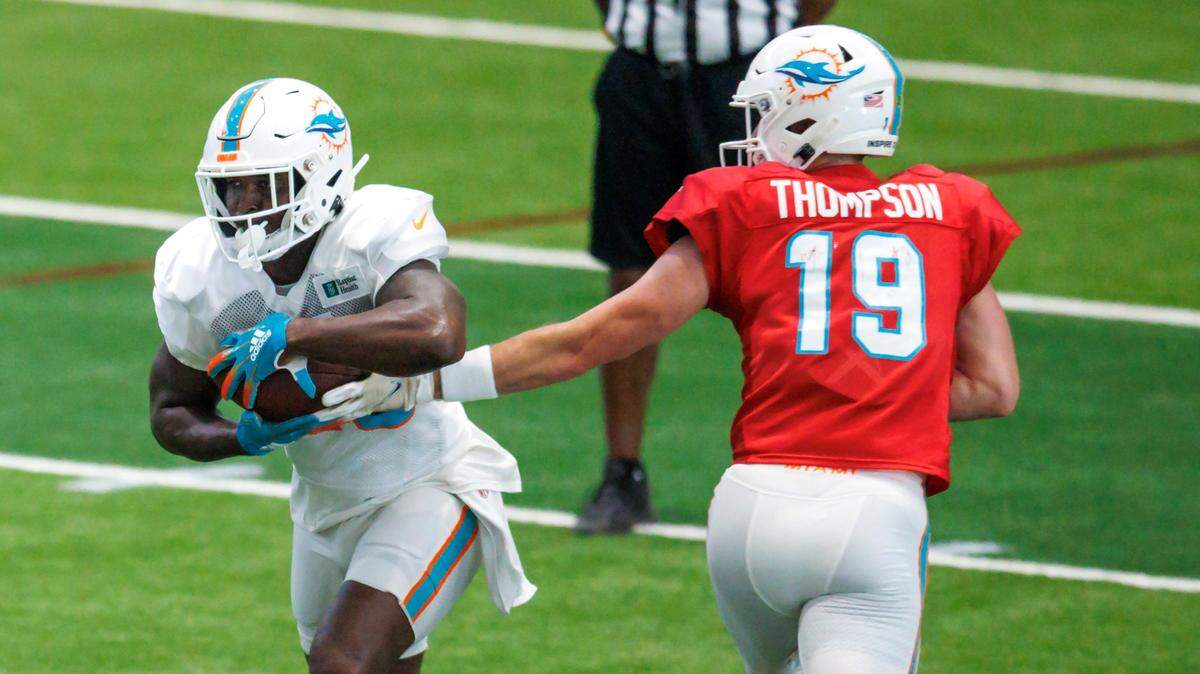 El wide receiver de los Dolphins Sony Michel recibe un pase del quarterback Skylar Thompson en una práctica del equipo el 18 de agosto de 2022 en el Hard Rock Stadium, en Miami Gardens, Florida.