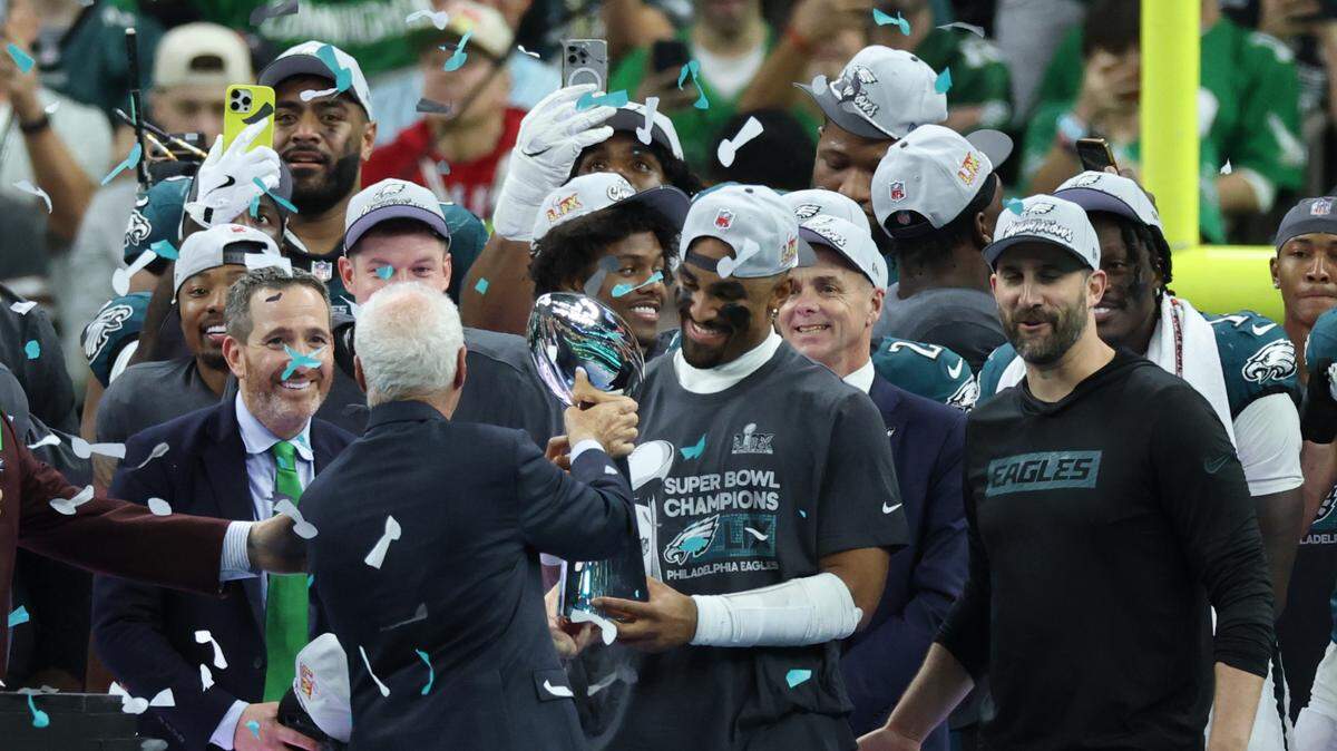 El dueño de los Eagles de Filadelfia Jeffrey Lurie posa con el trofeo Vince Lombardi con el quarterback Jalen Hurts tras vencer a los Chiefs de Kansas City en el Super Bowl LIX, celebrado el 9 de febrero de 2025 en Nueva Orleans.