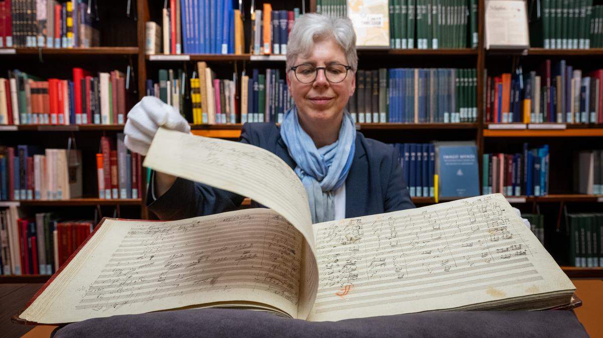 Martina Rebmann, la directora del departamento de música de la Biblioteca Estatal de Berlín, muestra una parte de la partitura original de la Novena Sinfonía de Beethoven, el 10 de abril de 2024, en Berlín. La obra musical fue tocada por primera vez el 7 de mayo de 1824, y la partitura fue encuadernada en 1850.