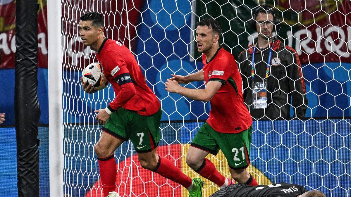 Los jugadores de Portugal Cristiano Ronaldo (izq.) y Diogo Jota recogen la pelota tras empatar el partido 1-1 ante la República Checa en la Eurocopa, celebrado el 18 de juio de 2024 en Leipzig, Alemania.