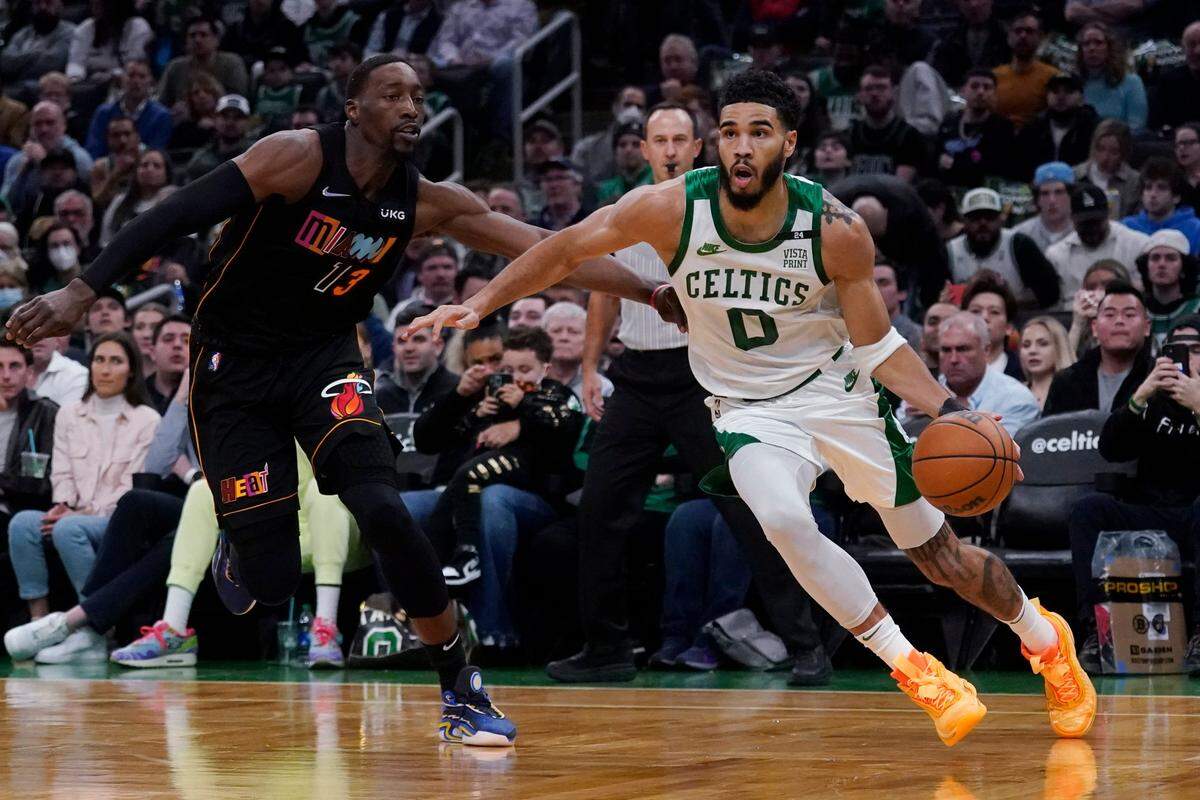 El jugador de los Celtics Jayson Tatum (der. ) conduce la pelota ante la marca de Bam Adebayo, del Heat de Miami, en el partido celebrado el 30 de marzo de 2022 en Boston.