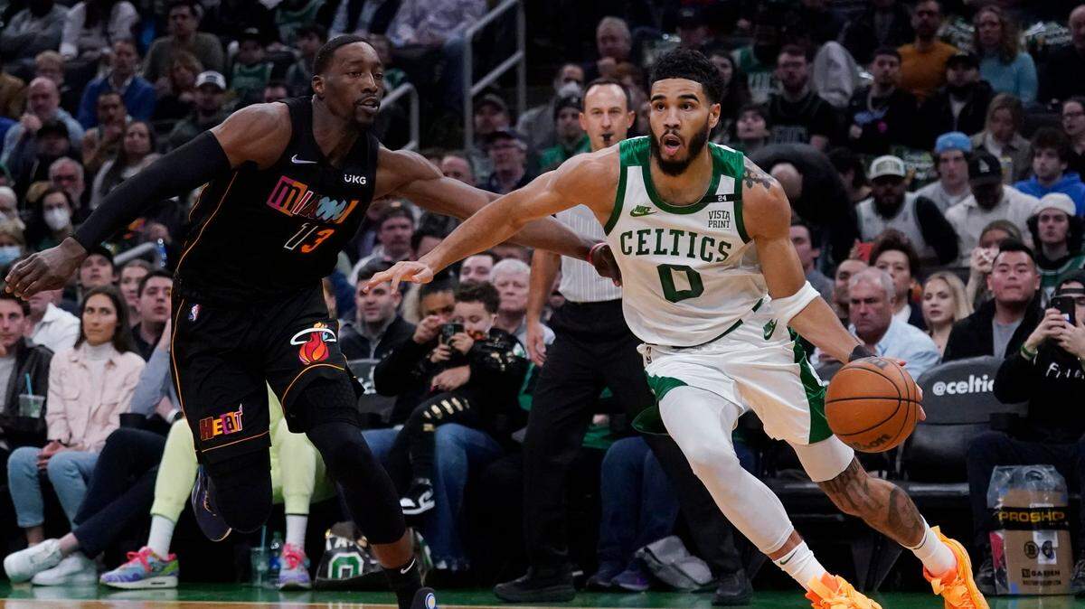 El jugador de los Celtics Jayson Tatum (der. ) conduce la pelota ante la marca de Bam Adebayo, del Heat de Miami, en el partido celebrado el 30 de marzo de 2022 en Boston.
