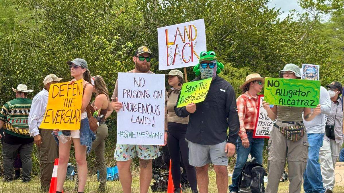 Un grupo de personas protesta frente a la cárcel de inmigración de alligator Alley en el Aeropuerto de Entrenamiento y Transición Dade-Collier.