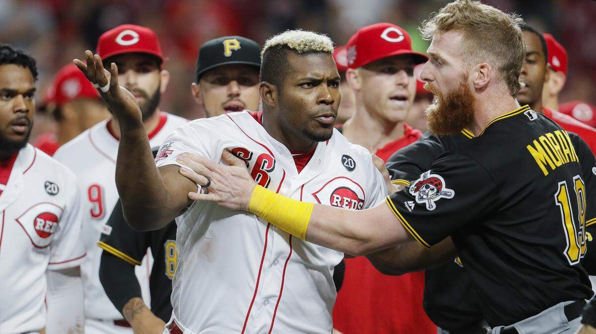 YASIEL PUIG es contenido por el tercera base de los Piratas Colin Moran (19) durante una bronca en la novena entrada de un juego en Cincinnati el 30 de julio de 2019.