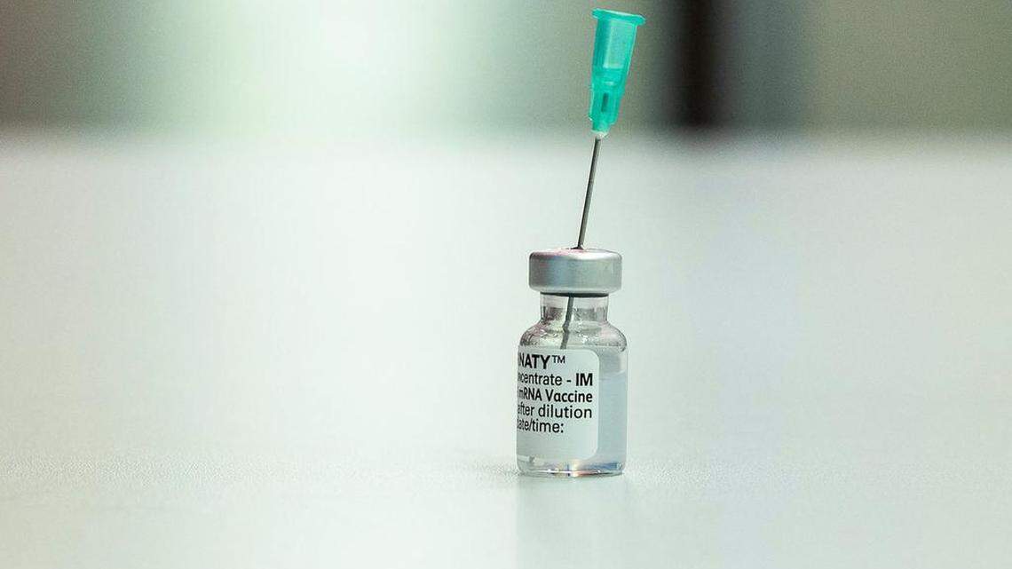 A vial with the Pfizer Biontech vaccine Comirnaty stands on a table at the vaccination center of German speciality chemicals company Evonik in Hanau, western Germany.