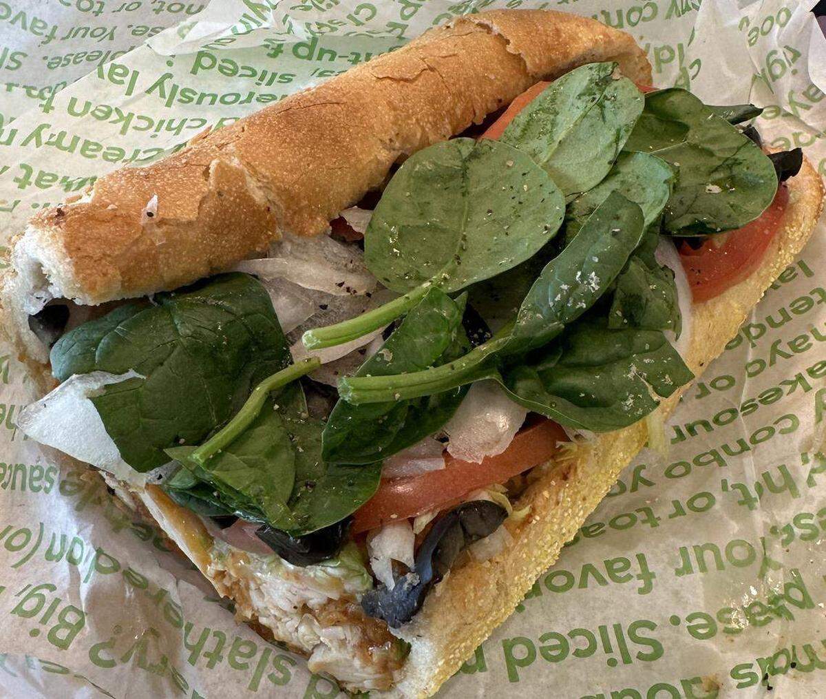 Este Dolphins Sub en particular venía con ingredientes a gusto del cliente, como espinacas, tomates, aceitunas negras y otras verduras. El ingrediente principal de la versión de 2025, las tiras de pollo Publix Deli, se encuentra debajo.