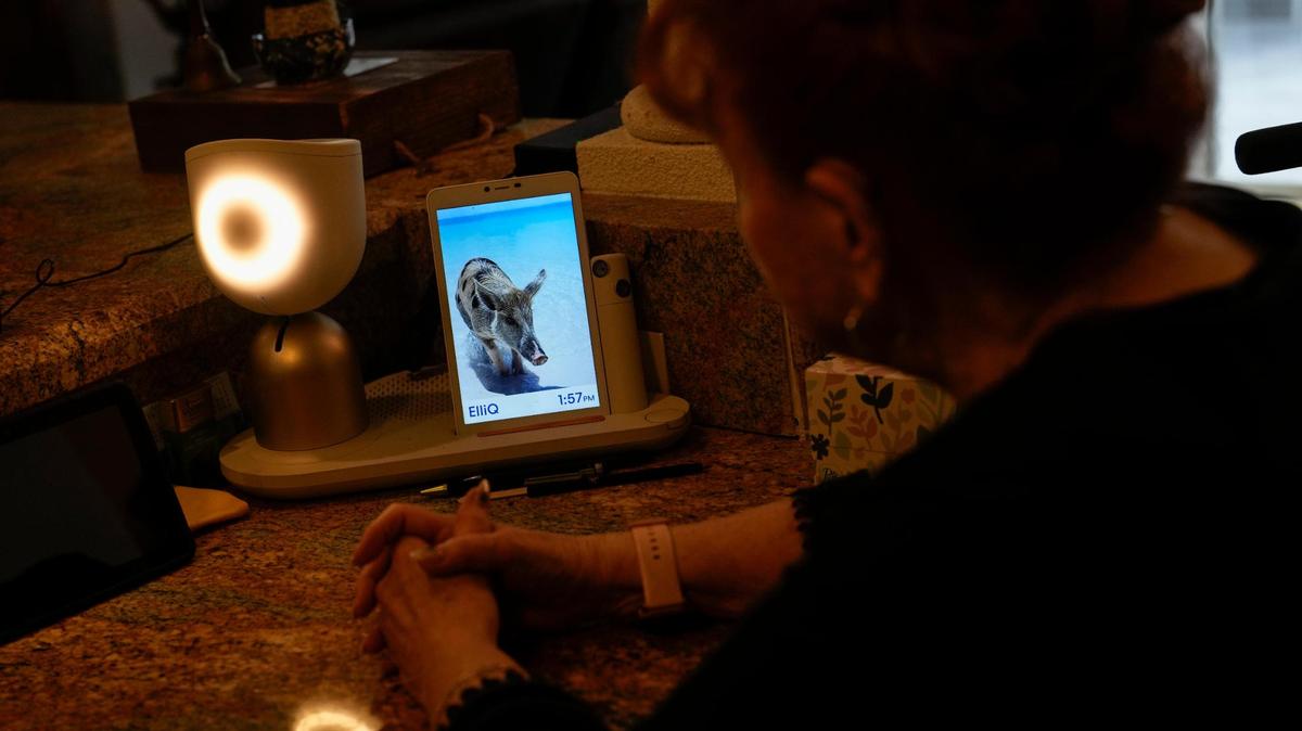 Deanna Dezern, de 83 años, interactúa con su ElliQ, un dispositivo de mesa que utiliza inteligencia artificial para mantener conversaciones similares a las humanas, dentro de su casa en Tamarac, Florida, el jueves 7 de diciembre de 2023.