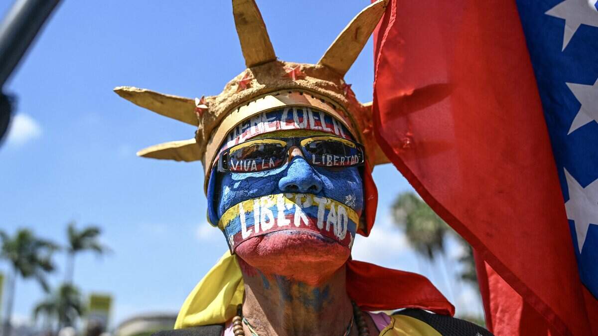TOPSHOT - An opponent to the government of Venezuelan interim President Delcy Rodriguez, fancy dressed as the Statue of Liberty, demonstrates in demand of salary and pensions raises in Caracas on April 9, 2026. (Photo by Juan BARRETO / AFP via Getty Images)