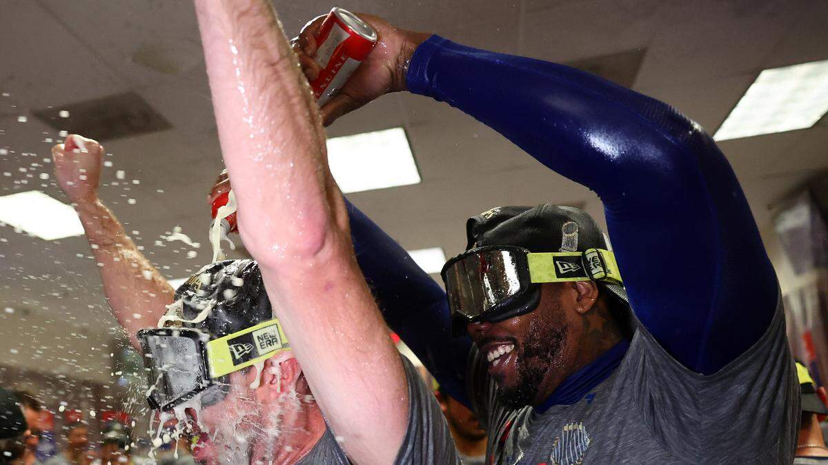 El relevista cubano de los Rangers de Texas Aroldis Chapman (der.) celebra en el vestuario con el abridor Max Scherzer tras ganar la Serie Mundial ante los Diamondbacks, el 1ro de noviembre en Phoenix, Arizona.