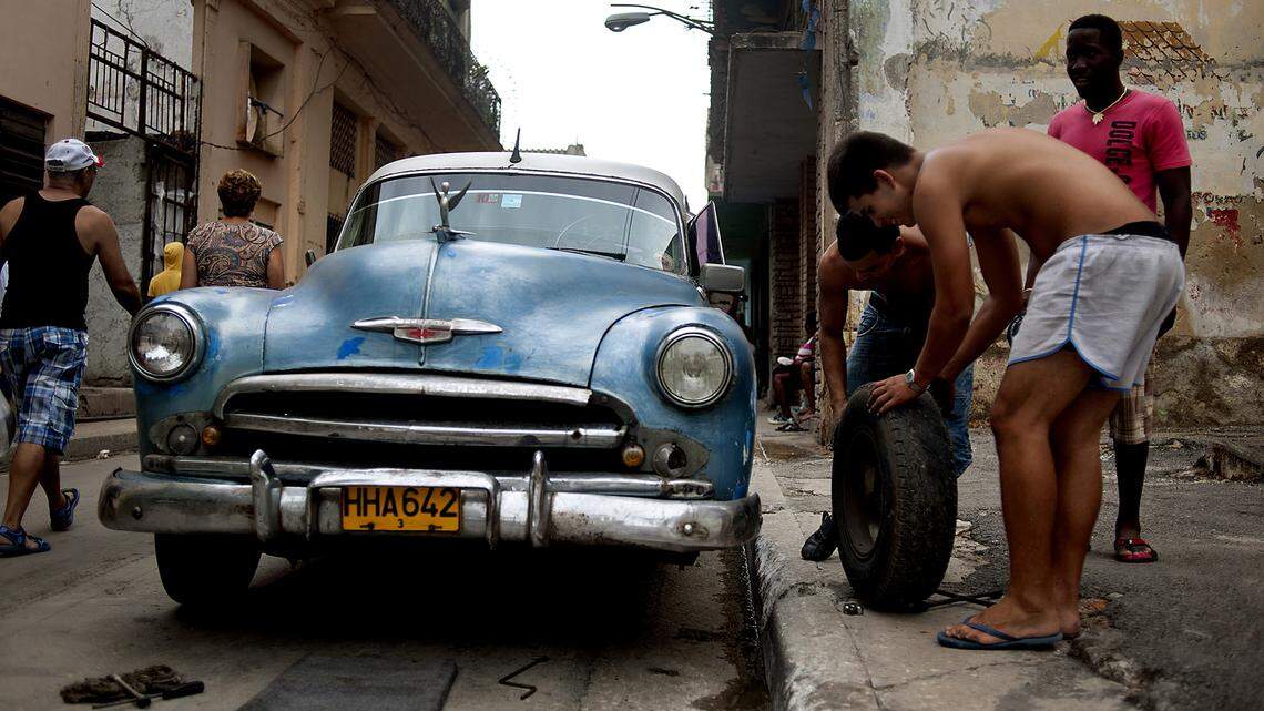 Cubanos reparan un auto clásico norteamericano en La Habana.