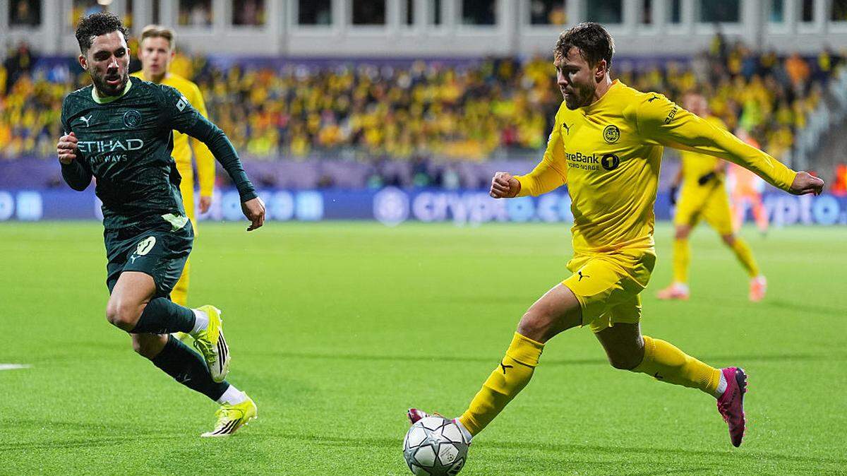 El jugador del Bodo/Glimt Fredrik Andre Bjorkan (der.) corre con el balón ante la marca de Rayan Cherki, del Manchester City, en el partido de la Liga de Campeones celebrado el 20 de enero de 2026 en Bodo, Noruega. 