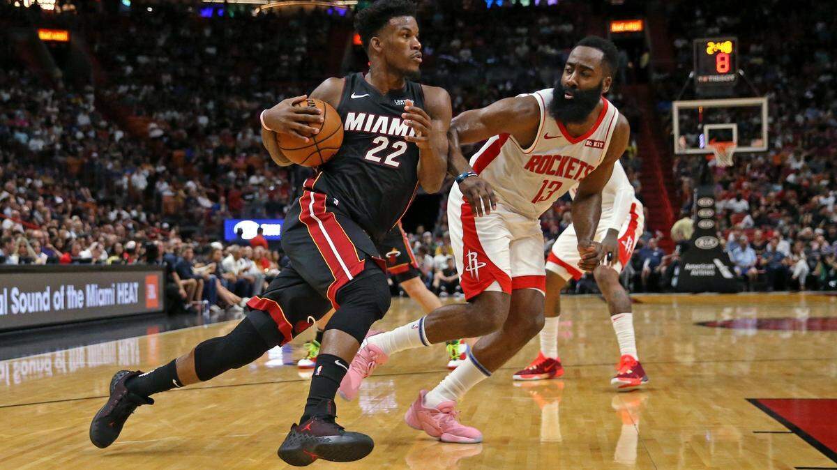 El astro del Heat Jimmy Butler (22) entra al aro ante la marca del estelar jugador de los Rockets James Harden (13), el 3 de noviembre del 2019 en el AmericanAirlines Arena.