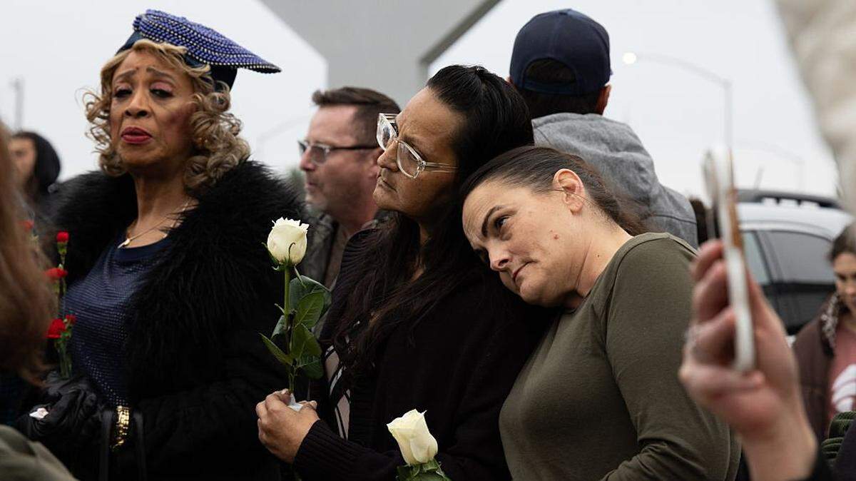Monique Flores (centro) y Carlene Britt (der.) participan en una vigilia el 30 de noviembre de 2025 en Stockton, California. 