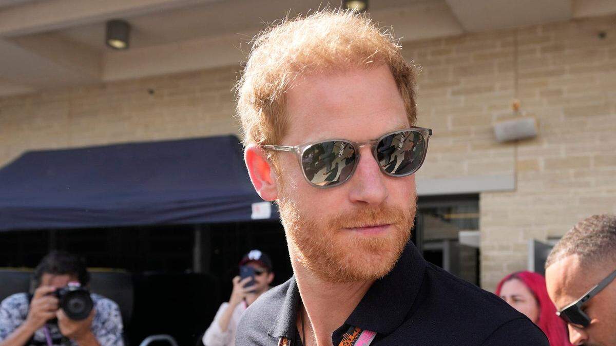 El príncipe Enrique, duque de Sussex, izquierda, camina detrás del paddock en el Gran Premio Lenovo de Estados Unidos de Fórmula 1 en el Circuito de las Américas el domingo 22 de octubre de 2023.