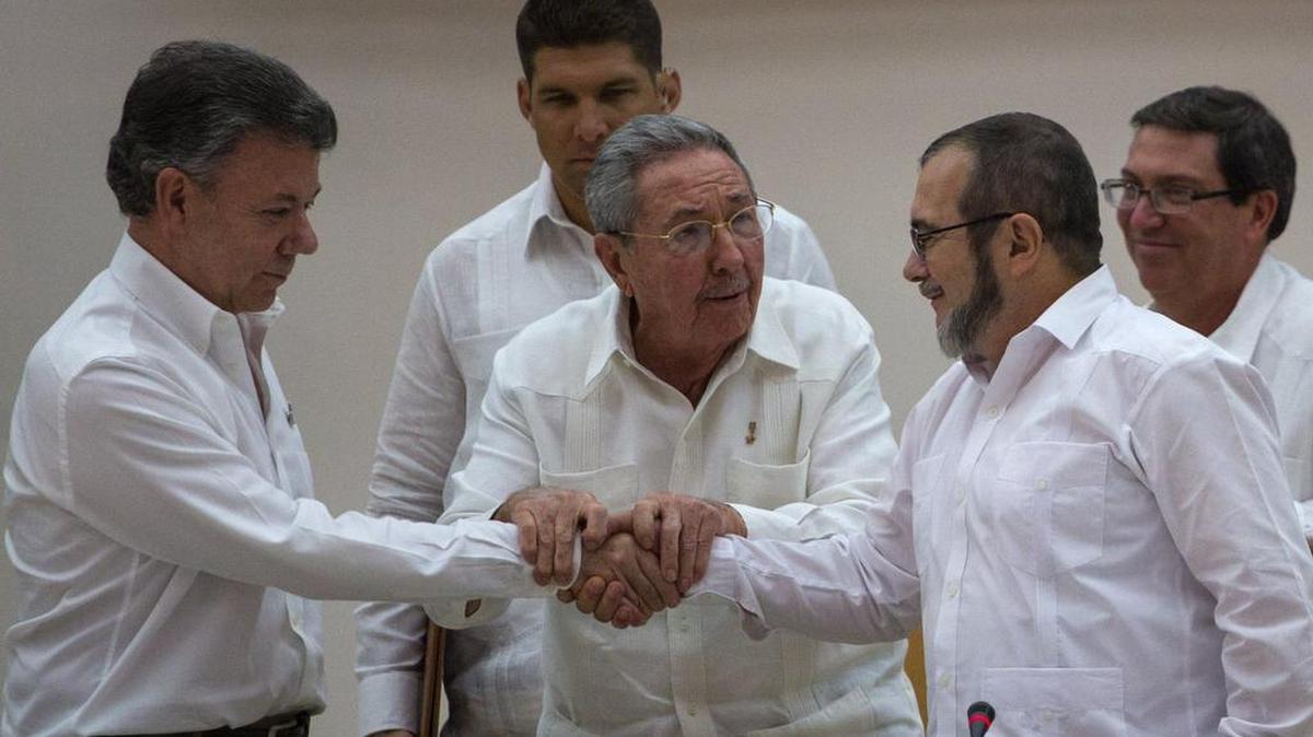 El presidente colombiano Juan Manuel Santos (izq.) y el jefe de las FARC, Rodrigo Londoño, alias Timochenko, estrechan las manos en presencia del líder cubano Raúl Castro, el 23 de septiembre de 2015 en La Habana. Ese día fue anunciado el último acuerdo para llegar a un tratado final de paz.