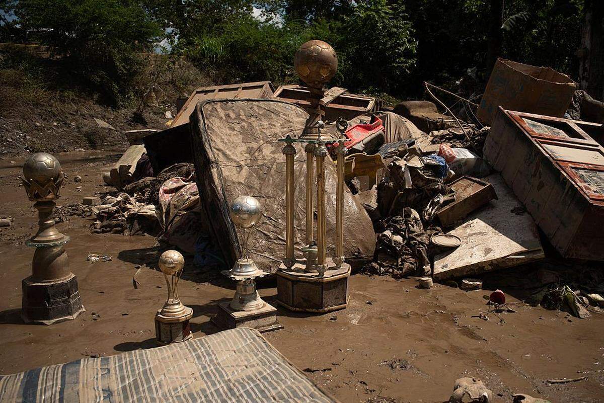 Football trophies covered in mud are pictured outside a flooded house caused by the heavy rains in the municipality of Alamo, Veracruz state, Mexico on October 12, 2025. The death toll from heavy rains in Mexico rose to 44 after the Mexican government confirmed three more fatalities on Sunday, as civilian and military rescuers struggle to clear roads and reach cut-off communities. (Photo by Hector Quintanar / AFP) (Photo by HECTOR QUINTANAR/AFP via Getty Images)          