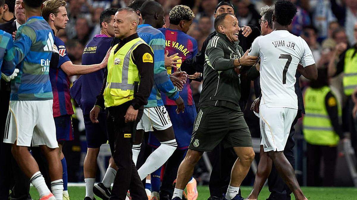El delantero del Real Madrid Vinicius Junior (#7) es separado mientras hace un gesto hacia Lamine Yamal y Raphinha, del Barcelona, después del partido celebrado el 26 de octubre de 2025 en el estadio Santiago Bernabéu de Madrid. 