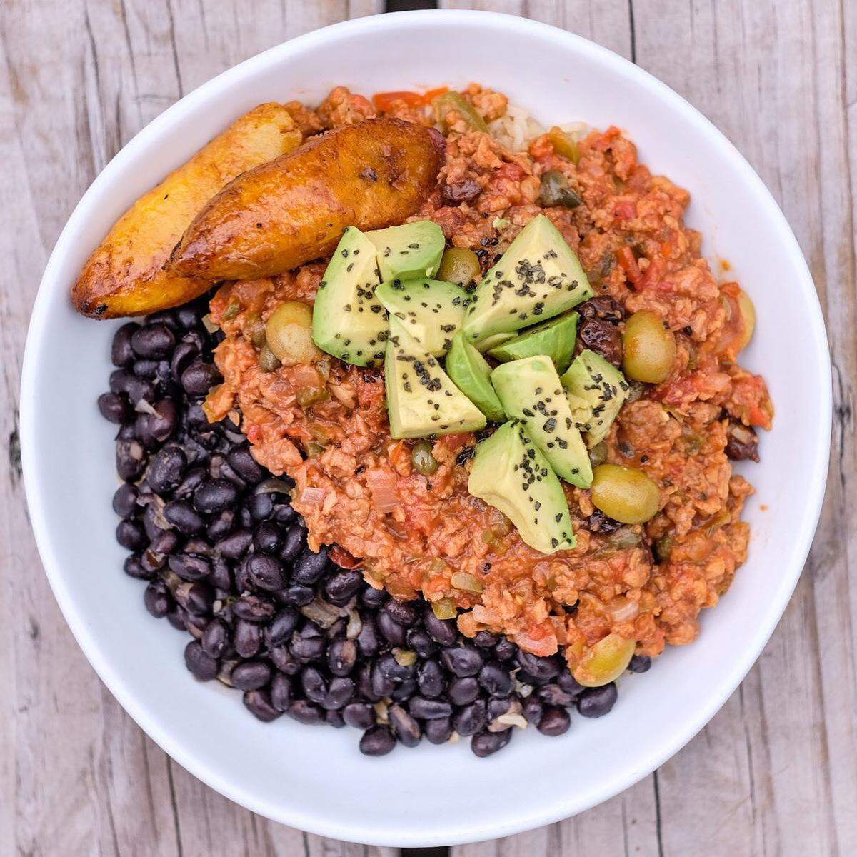 El delicioso bowl de Love Life Cafe tiene arroz integral, frijoles negros, plátanos maduros, aceitunas y aguacate fresco servido junto a un picadillo de Beyond Meat.