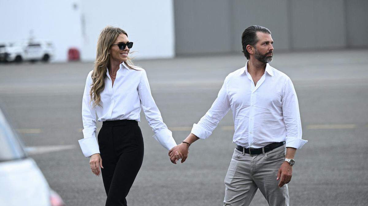 Donald Trump Jr. y Bettina Anderson caminan por la pista de aterrizaje mientras esperan la llegada del presidente Donald Trump y la primera dama Melania Trump en el aeropuerto de Teterboro, en Teterboro, Nueva Jersey, el 13 de julio de 2025.