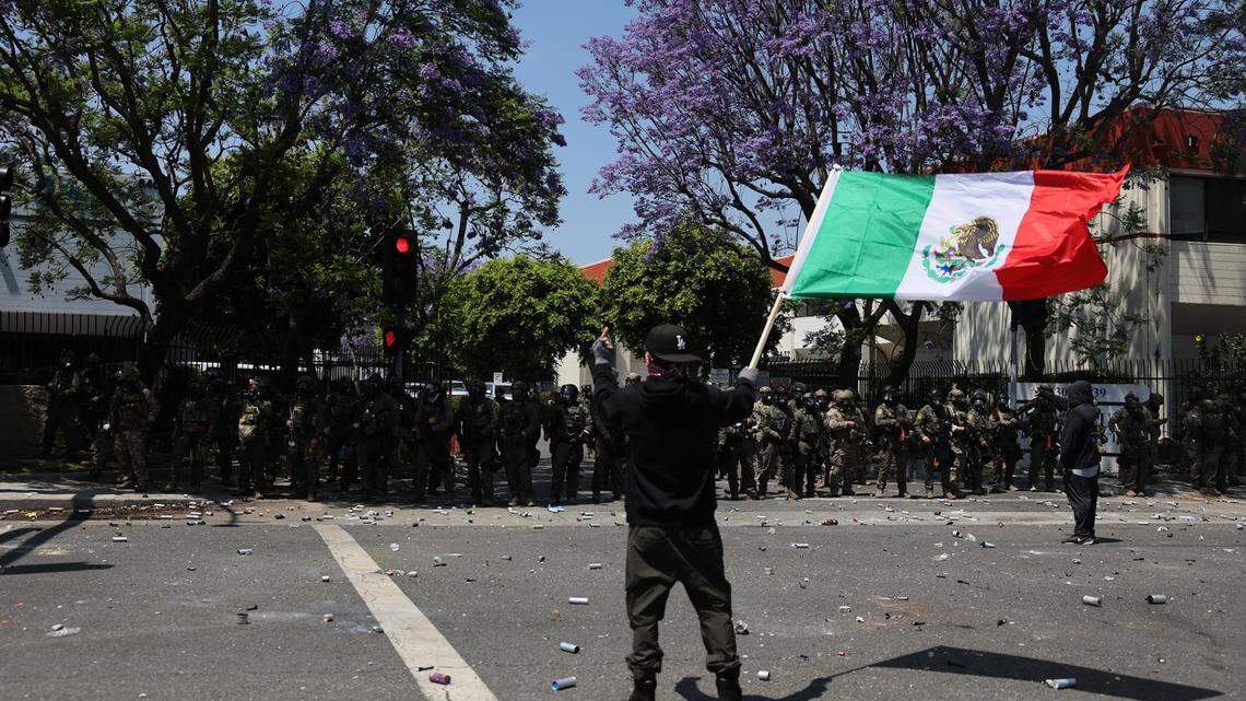 Fotografía del sabado 7 de junio de una manifestante sosteniendo una bandera mexicana durante una protesta contra las redadas de la Policía de Inmigración y Control de Aduanas (ICE) en Paramount, Condado Los Ángeles, California. La bandera roja, blanca y verde de México se ha convertido en un símbolo distintivo de las protestas contra las redadas migratorias en Los Ángeles, lo que ha irritado a republicanos y miembros del Gobierno del presidente estadounidense, Donald Trump, que lo califican como muestra de una invasión.