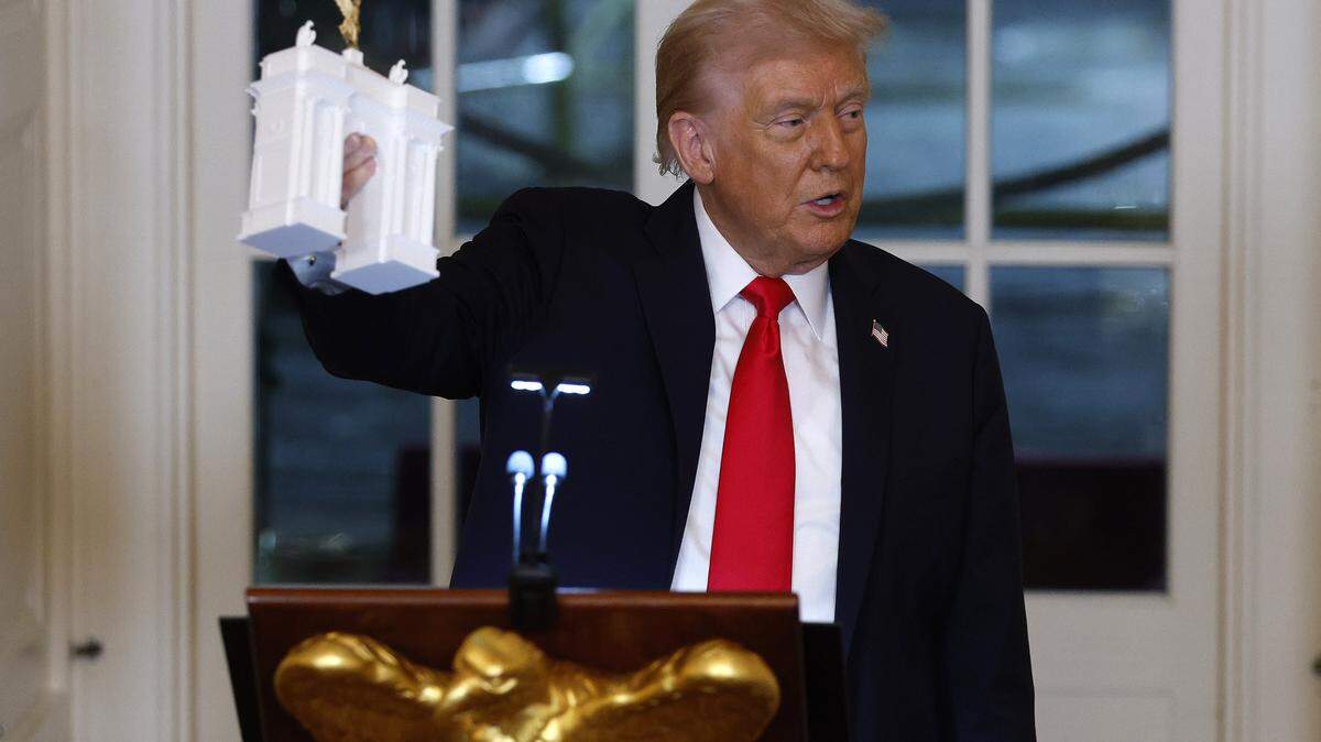 WASHINGTON, DC - OCTOBER 15: U.S. President Donald Trump holds models of an arch as he delivers remarks during a ballroom fundraising dinner in the East Room of the White House on October 15, 2025 in Washington, DC. Trump hosted organizations and individuals for a fundraising dinner for the new $250 million ballroom addition currently under construction at the White House. (Photo by Kevin Dietsch/Getty Images)