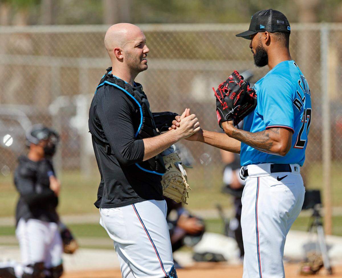 El derecho dominicano de los Marlins Sandy Alcántara (der.) saluda al receptor Jacob Stallings en una práctica en la pretemporada, el 16 de febrero de 2023 en el Roger Dean Chevrolet Stadium en Jupiter, Florida.