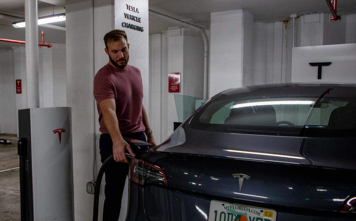 Clayton Williams carga su Tesla en un supercargador en el Brickell City Center el viernes 23 de septiembre. Prefiere conducir al estacionamiento en lugar de usar el cargador en su complejo de apartamentos porque le lleva menos tiempo. 
