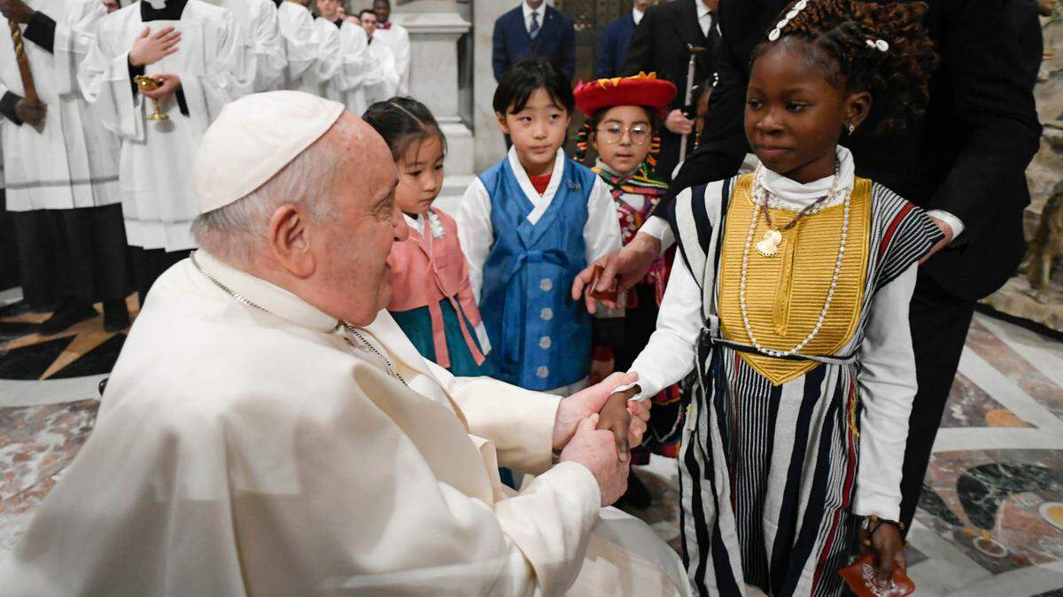 El papa Francisco saluda a varios niños durante la misa de Nochebuena, en la Basílica de San Pedro, El Vaticano, el domingo 24 de diciembre de 2023.