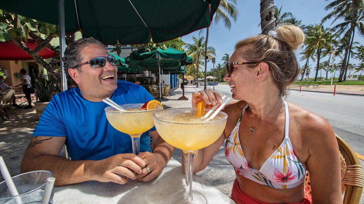 Nick Lo Presti y su esposa Kym Lo Presti disfrutan de sus bebidas en el News Cafe a lo largo de Ocean Drive en South Beach el miércoles 27 de mayo de 2020.