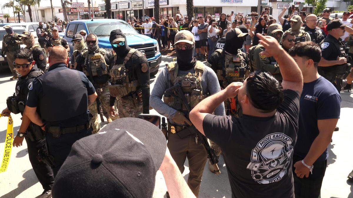 Residentes se enfrentan a agentes de la Policía de Inmigración y Aduanas (ICE) en la ciudad de Bell, California, el 19 de junio de 2025.